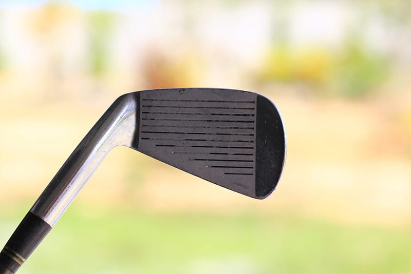 The dirty grooves of old golf clubs provide less backspin